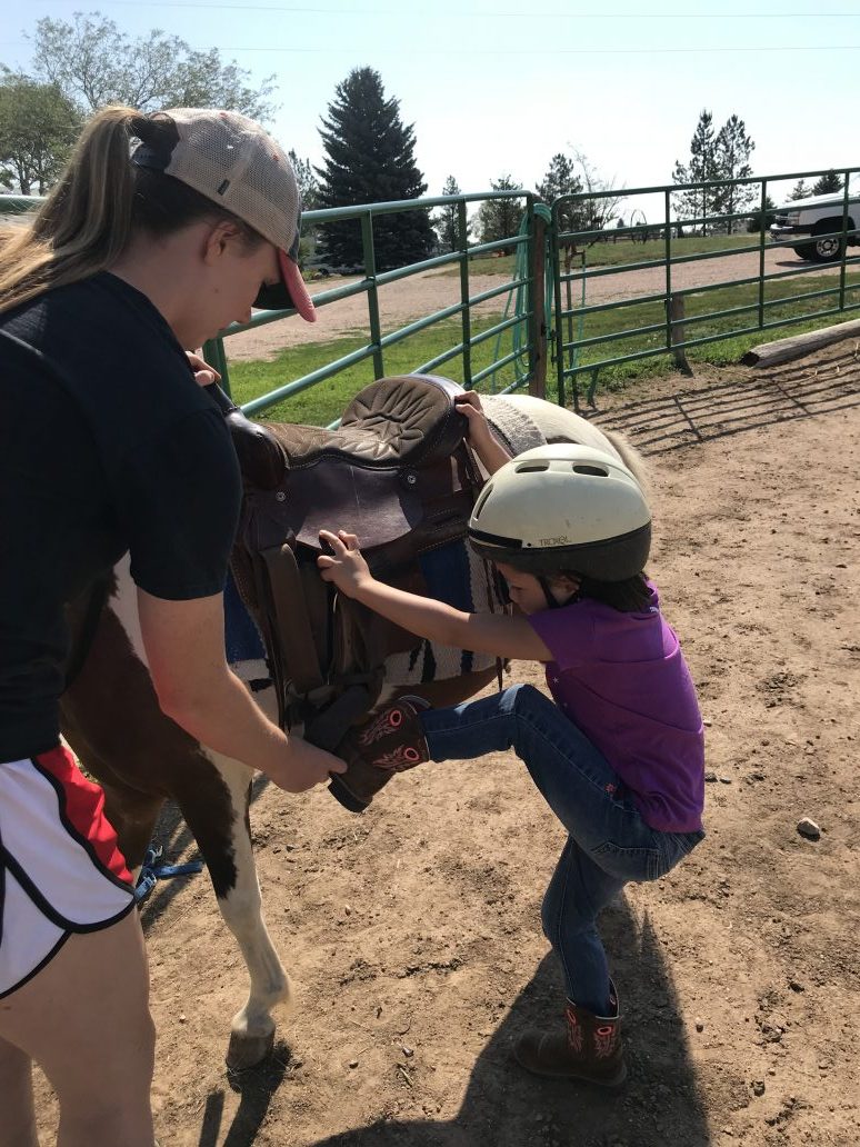 little kid getting on pony